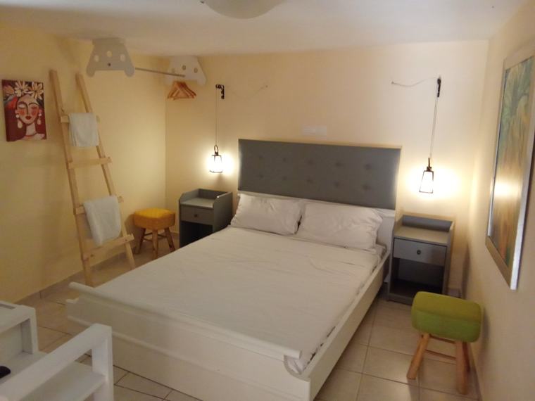 Third bedroom with cream headboard, wall mirror, flat-screen TV and fresh towels