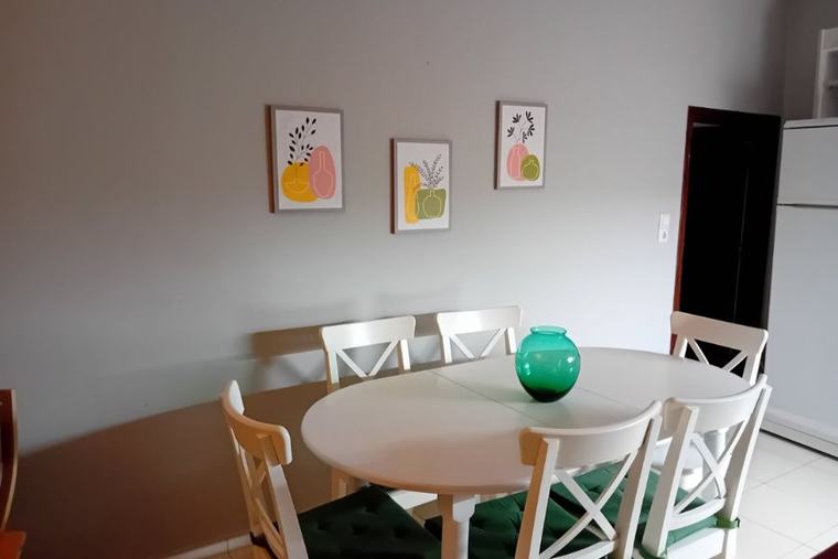 Dining corner with oval table and framed prints