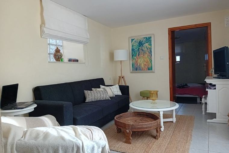 Living area with sofa, coffee table and satellite TV