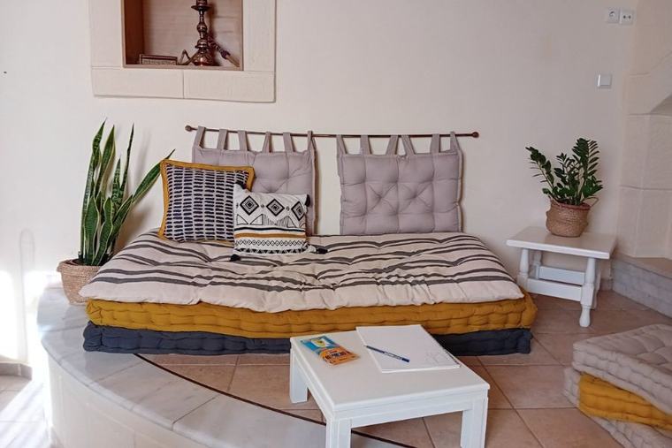Cosy reading nook with layered cushions and plants
