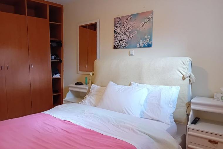 Second bedroom with wooden wardrobe and artwork