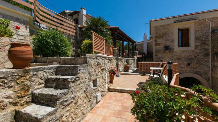 Stone courtyard with steps, terracotta pots and traditional facade