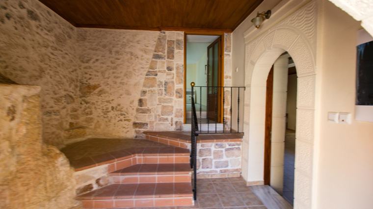 Restored stone interior with arch, timber ceiling and tiled steps