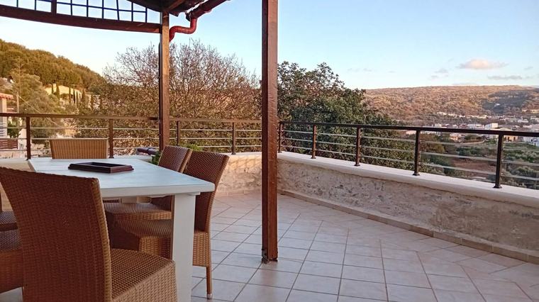 Terrace dining table at dusk with panoramic views over the Cretan hills
